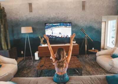 woman sitting on brown sofa watching TV